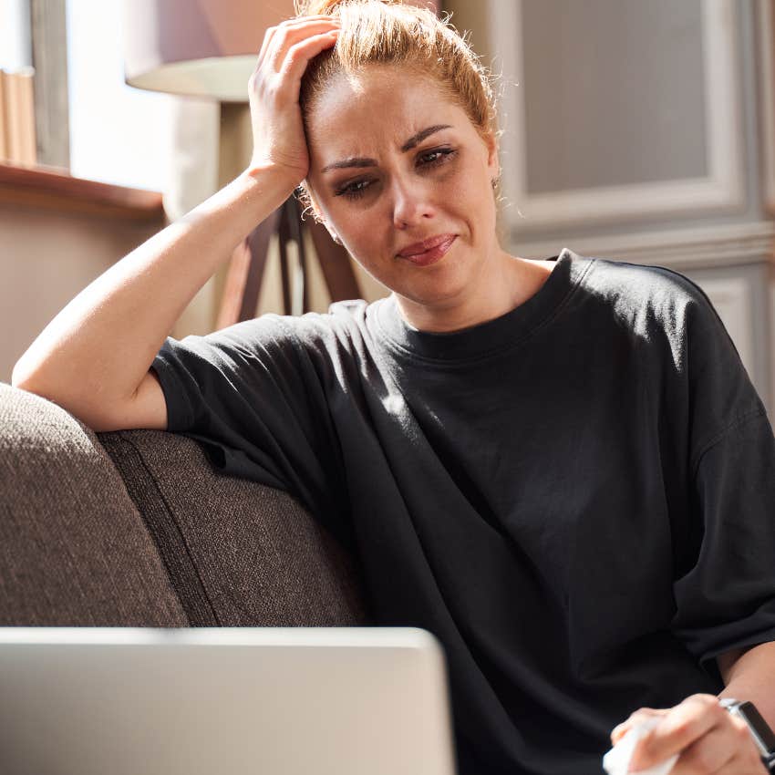 Woman crying while writing an email to another man