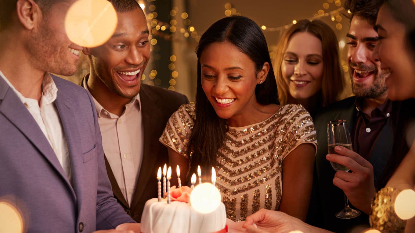 Woman blowing out candles with her friends on her birthday