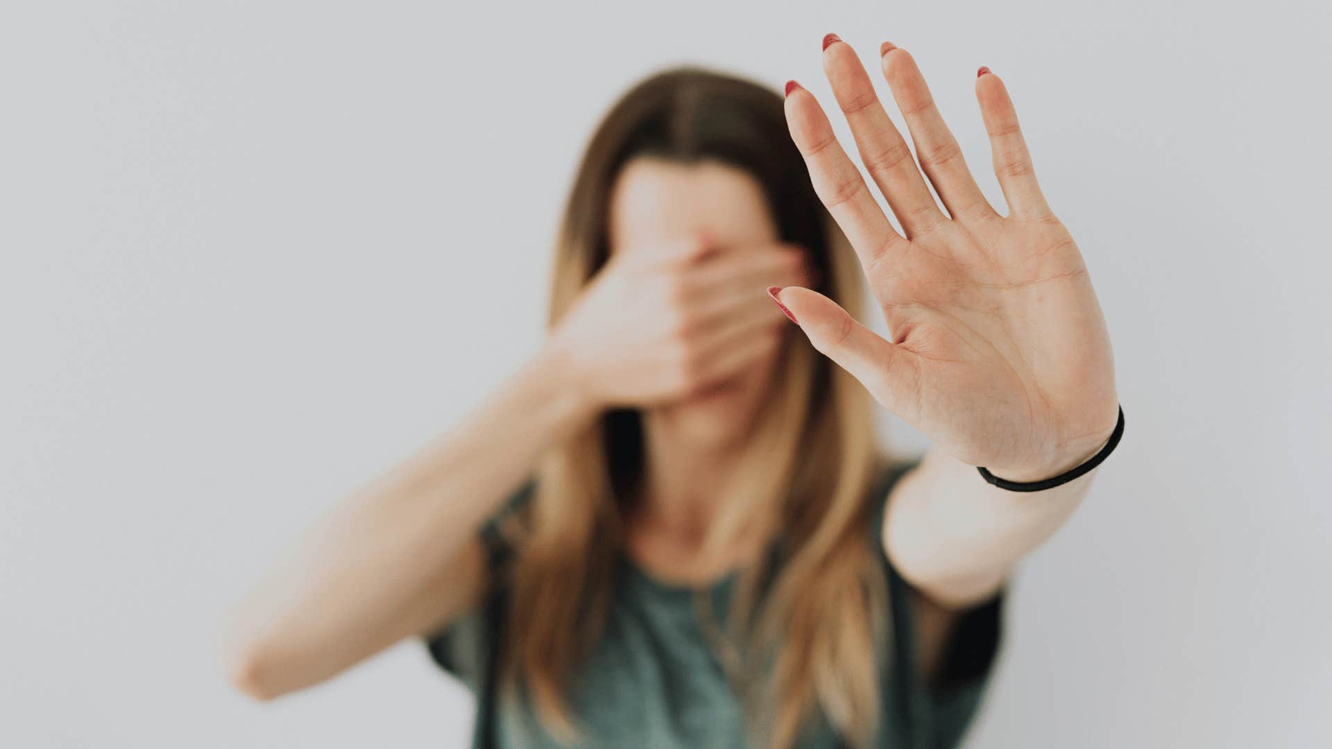 woman holding hand up with palm out to stop someone