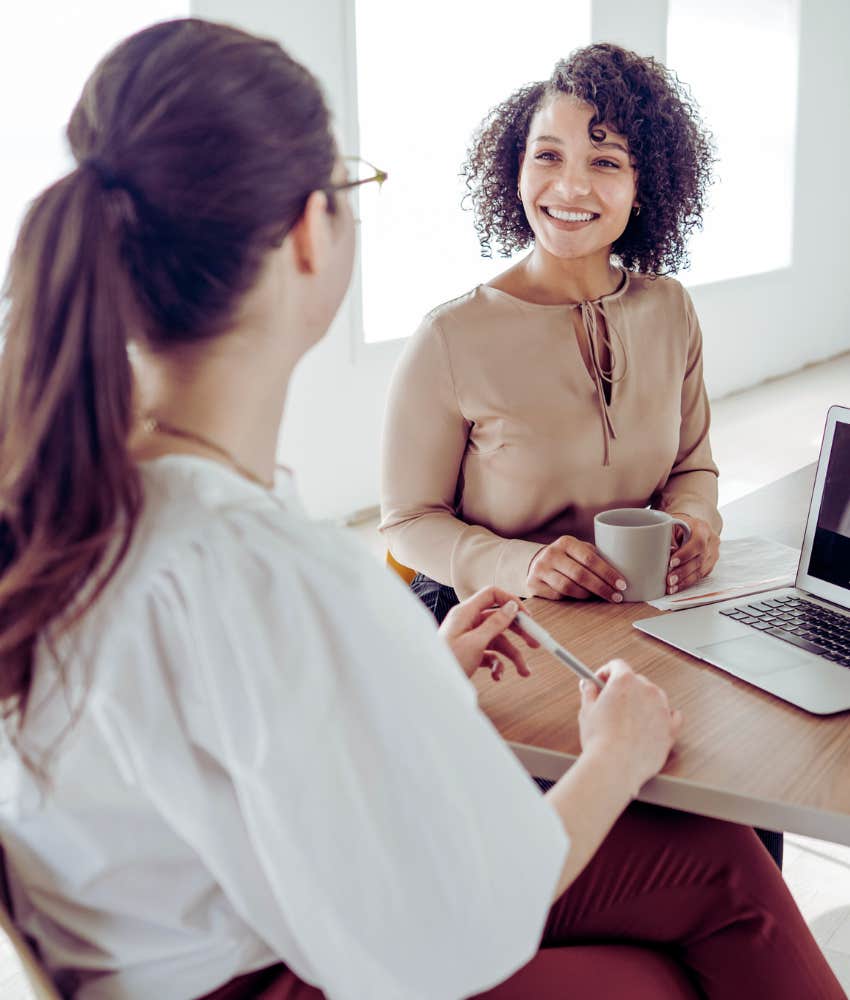 woman in job interview smiling with a cup of coffee