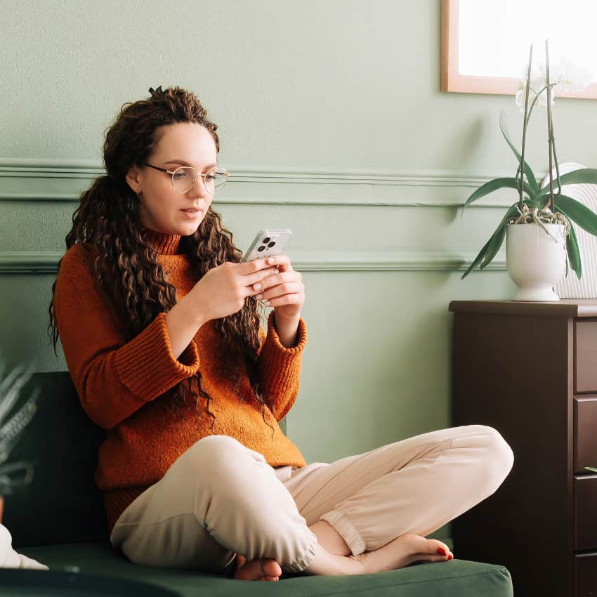 Teacher relaxing while looking at texts from her principal. 