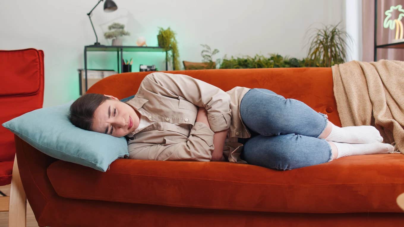 Woman at home and in pain because of period cramps