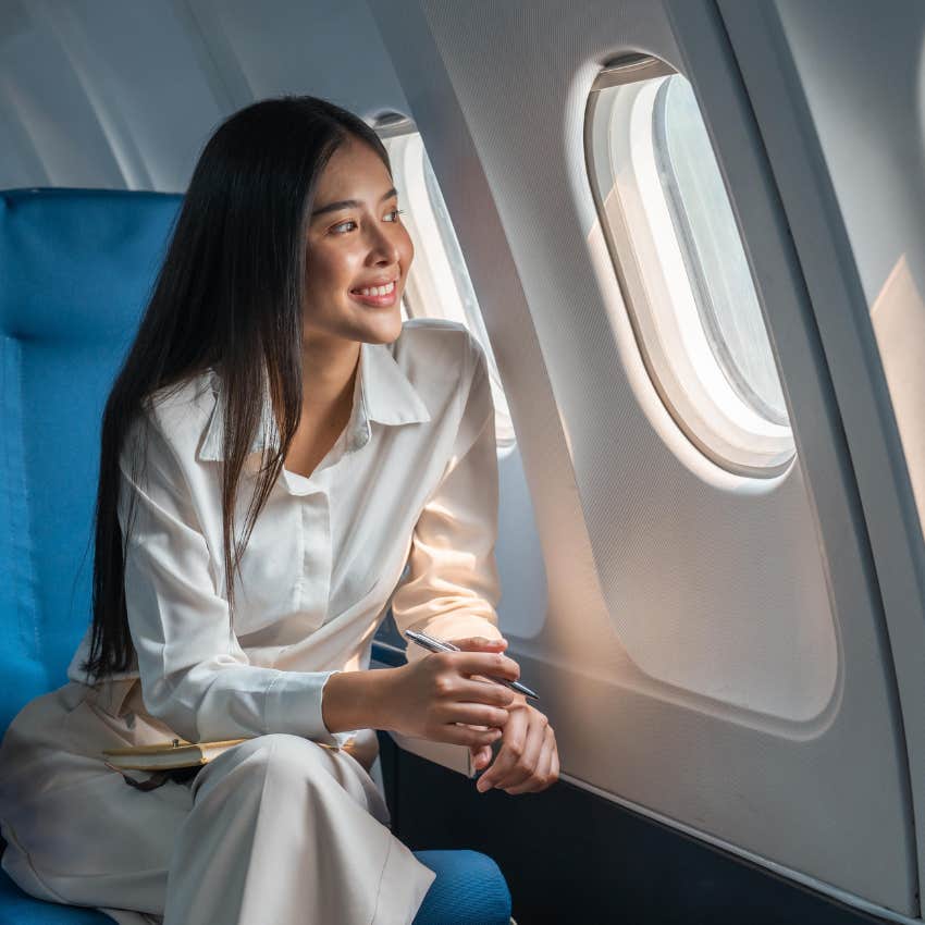 Passenger sitting on an airplane looking out the window. 