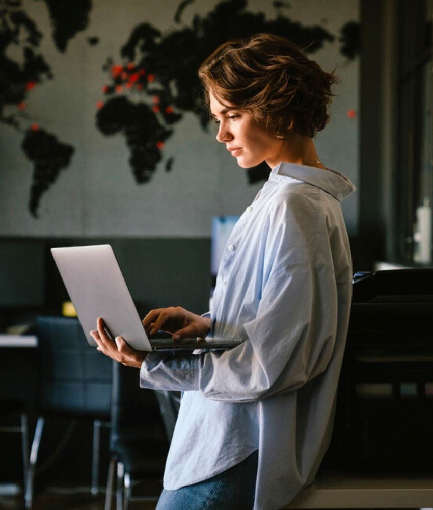 Woman standing and working on laptop