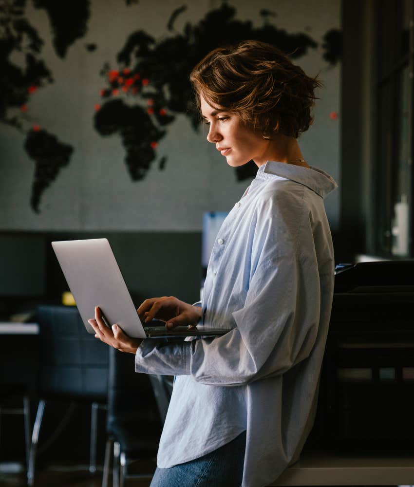 woman standing with laptop working hard