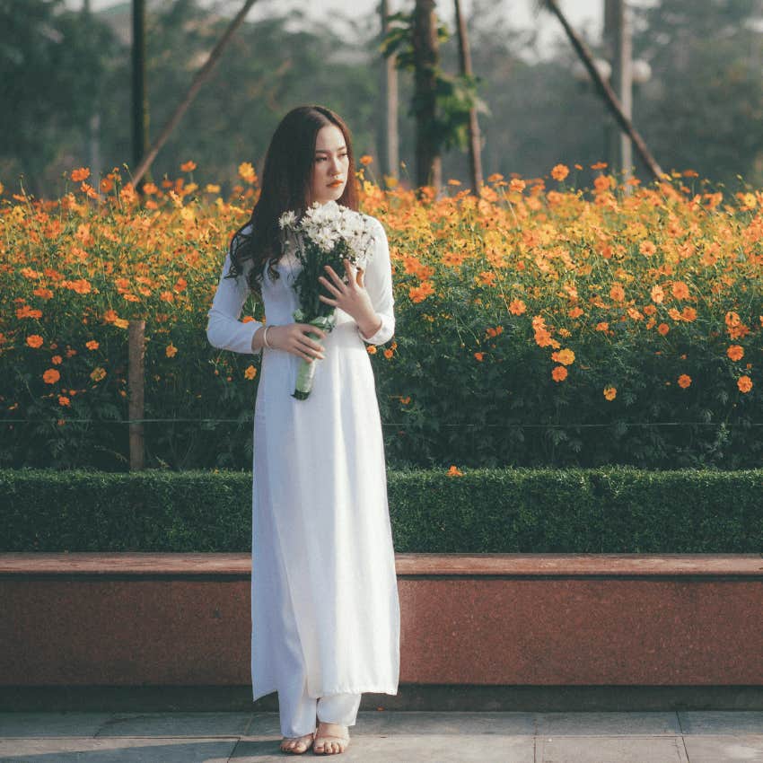 woman standing and holding flowers