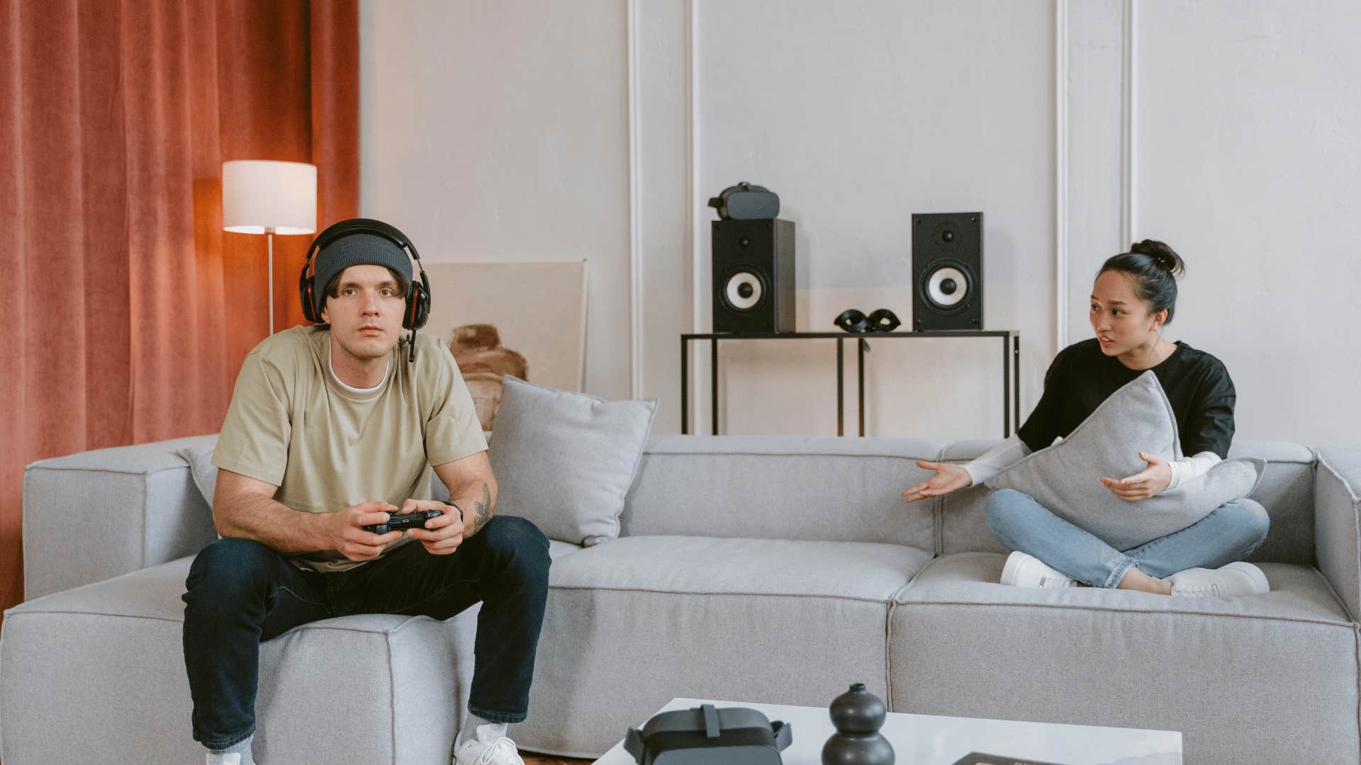 woman trying to talk to man who is playing video games