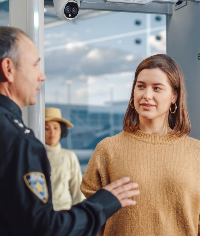 Woman talking to security after walking through a metal detector