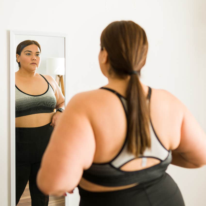 Woman looking in a mirror wants to lose weight