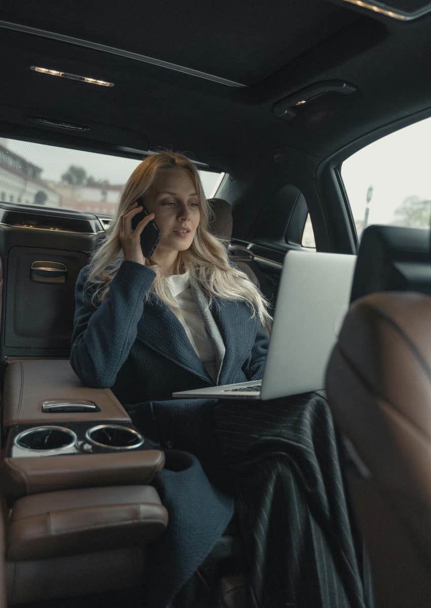 business woman working in the backseat of a luxury car