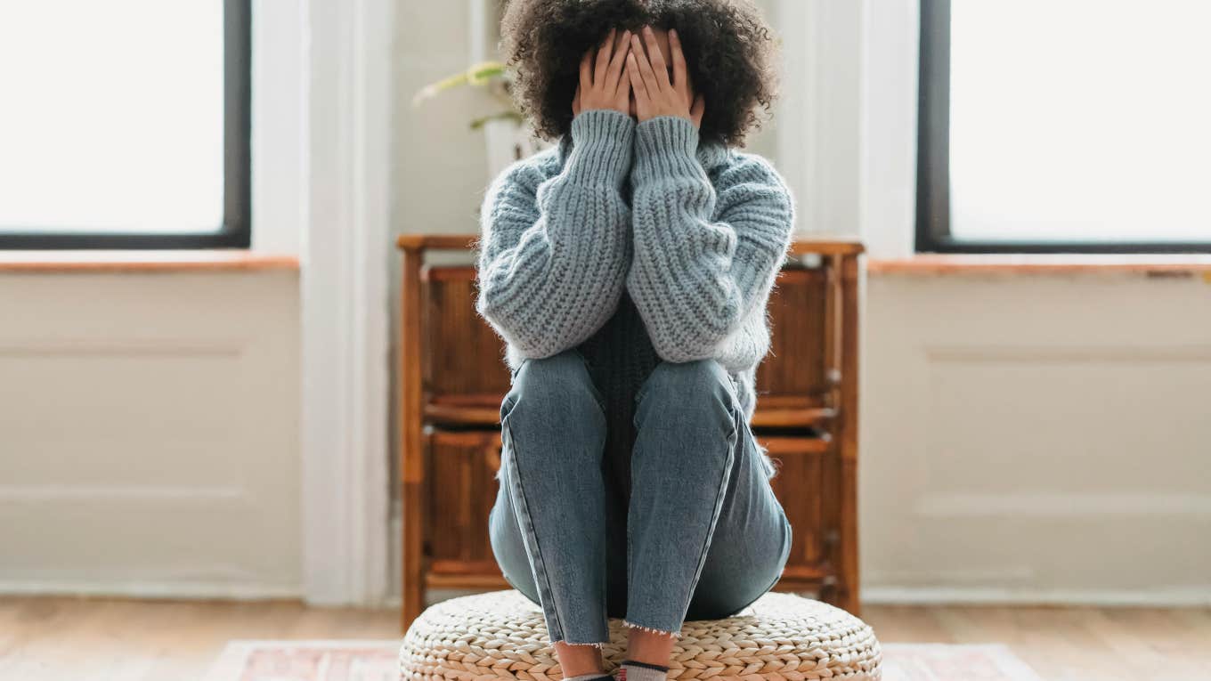 sad woman with her hands covering her face