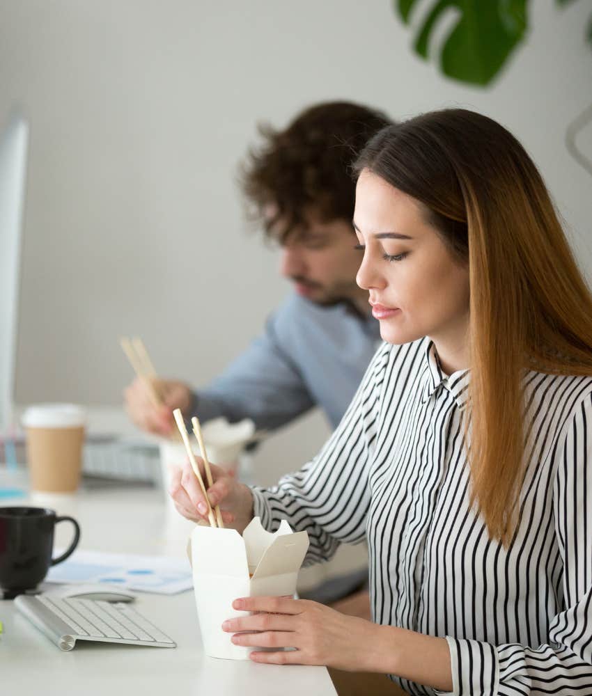 female employee eating out of a takeout container at her desk