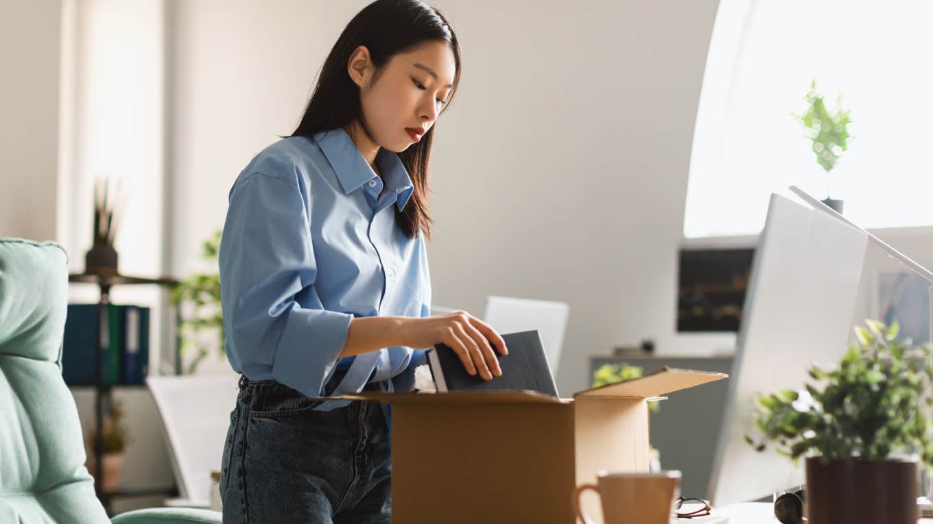 fired employee packing belongings in cardboard box