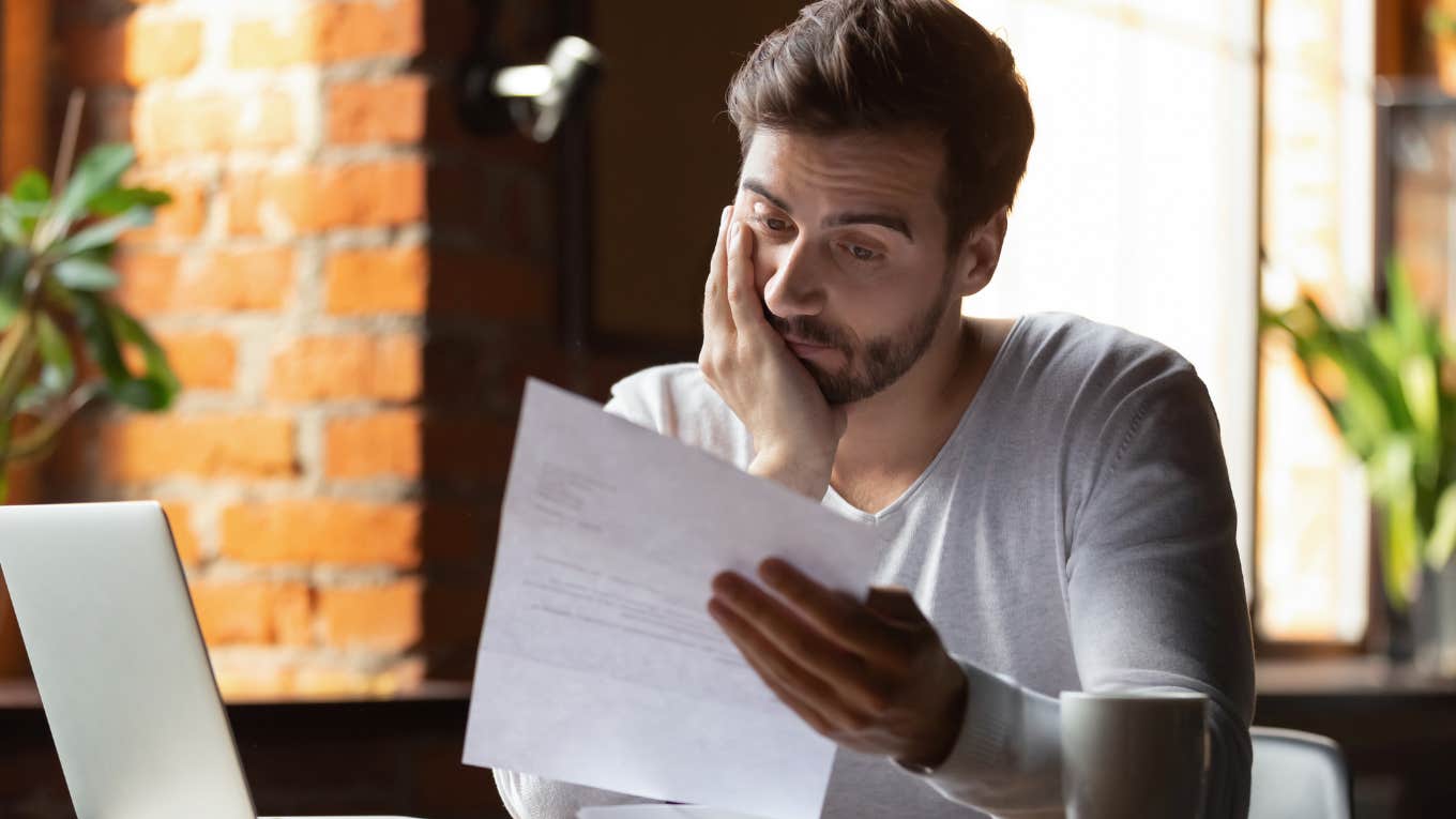 Worker reading over accommodation paperwork and looking stressed.