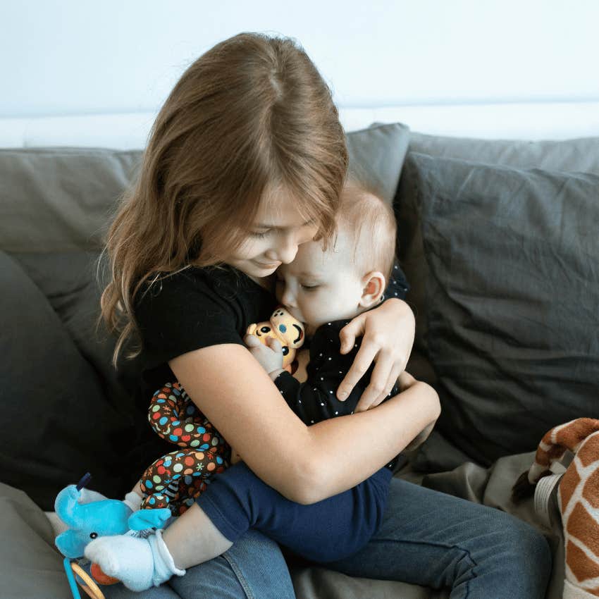 young girl holding baby