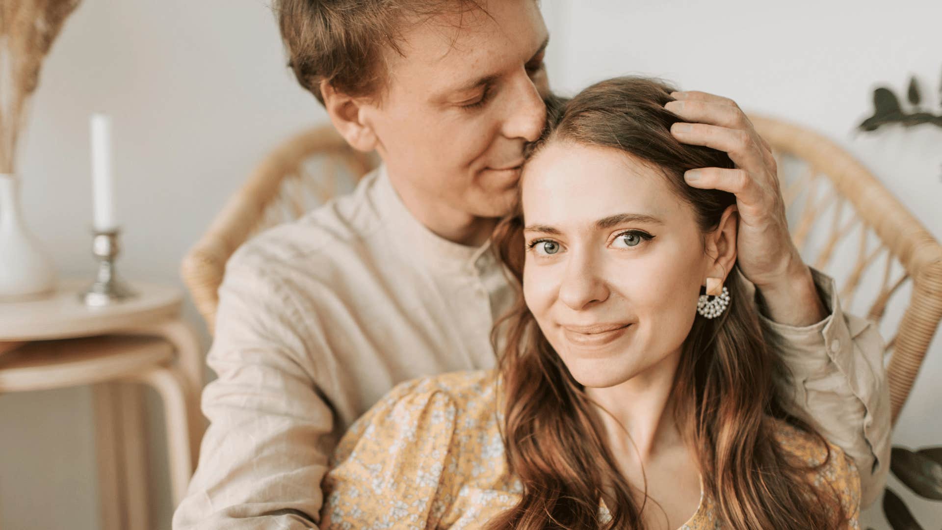 man holding his lips to womans head