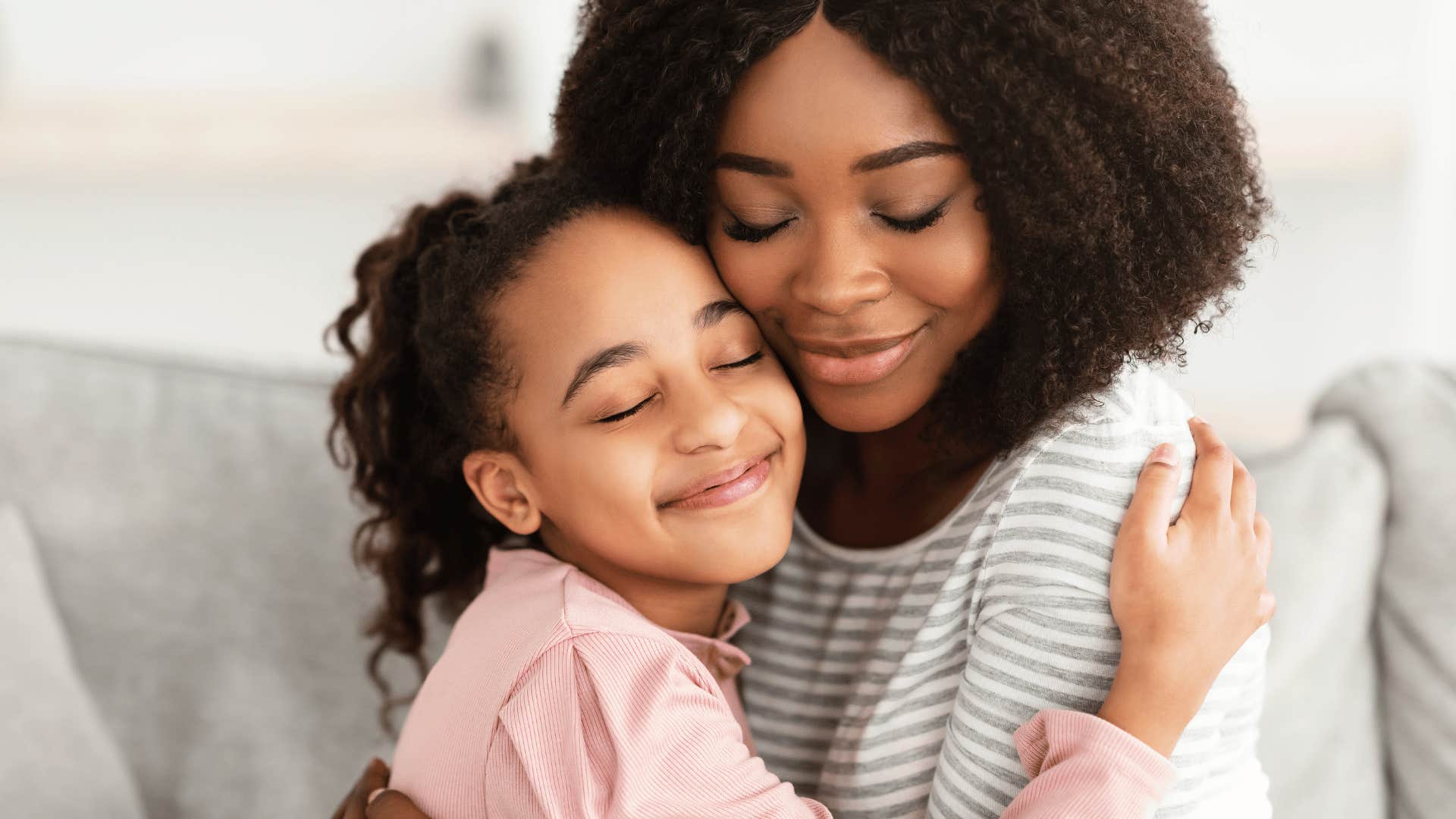 mother and daughter hugging with their eyes closed