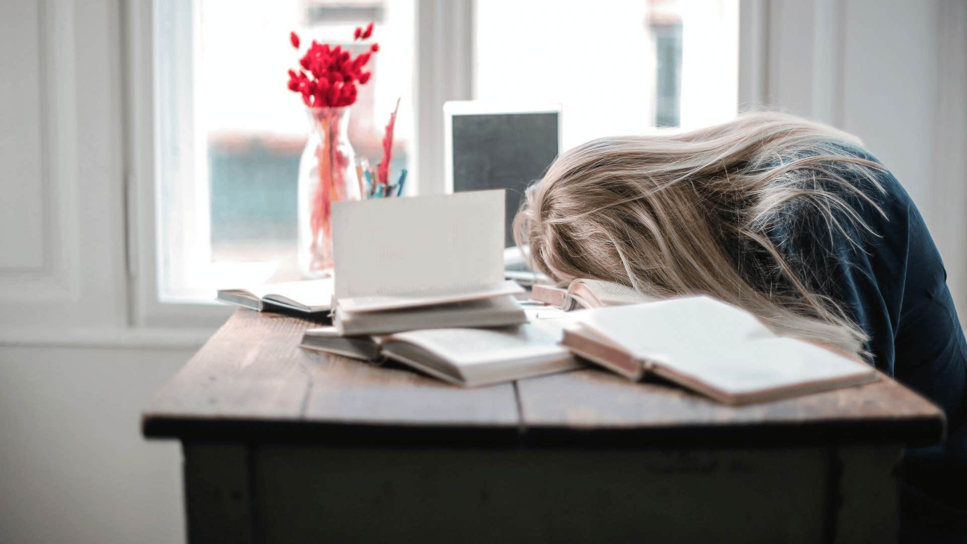 tired woman face down on open book