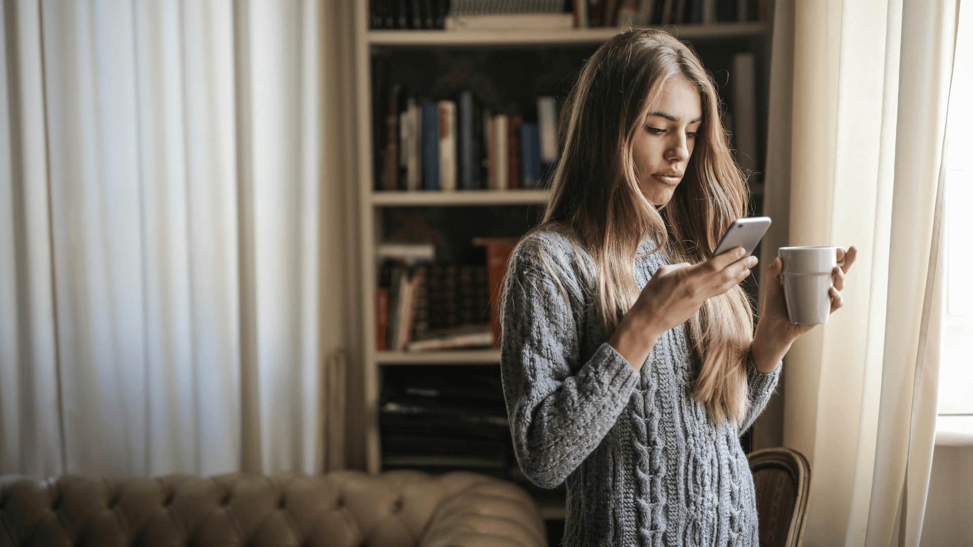 serious woman on phone and holding mug