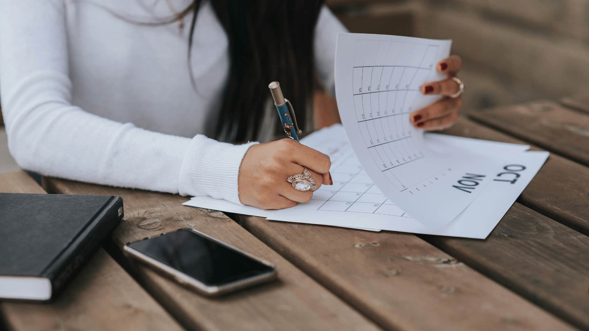 woman filling out a paper calendar