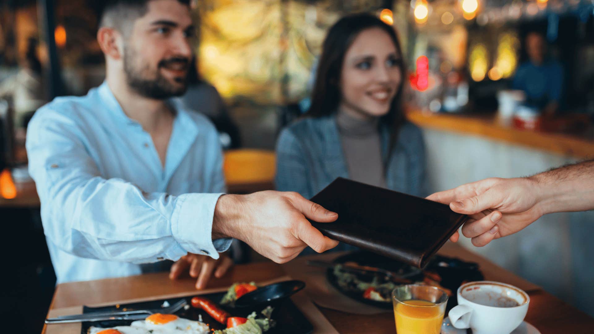 man accepting bill from waiter