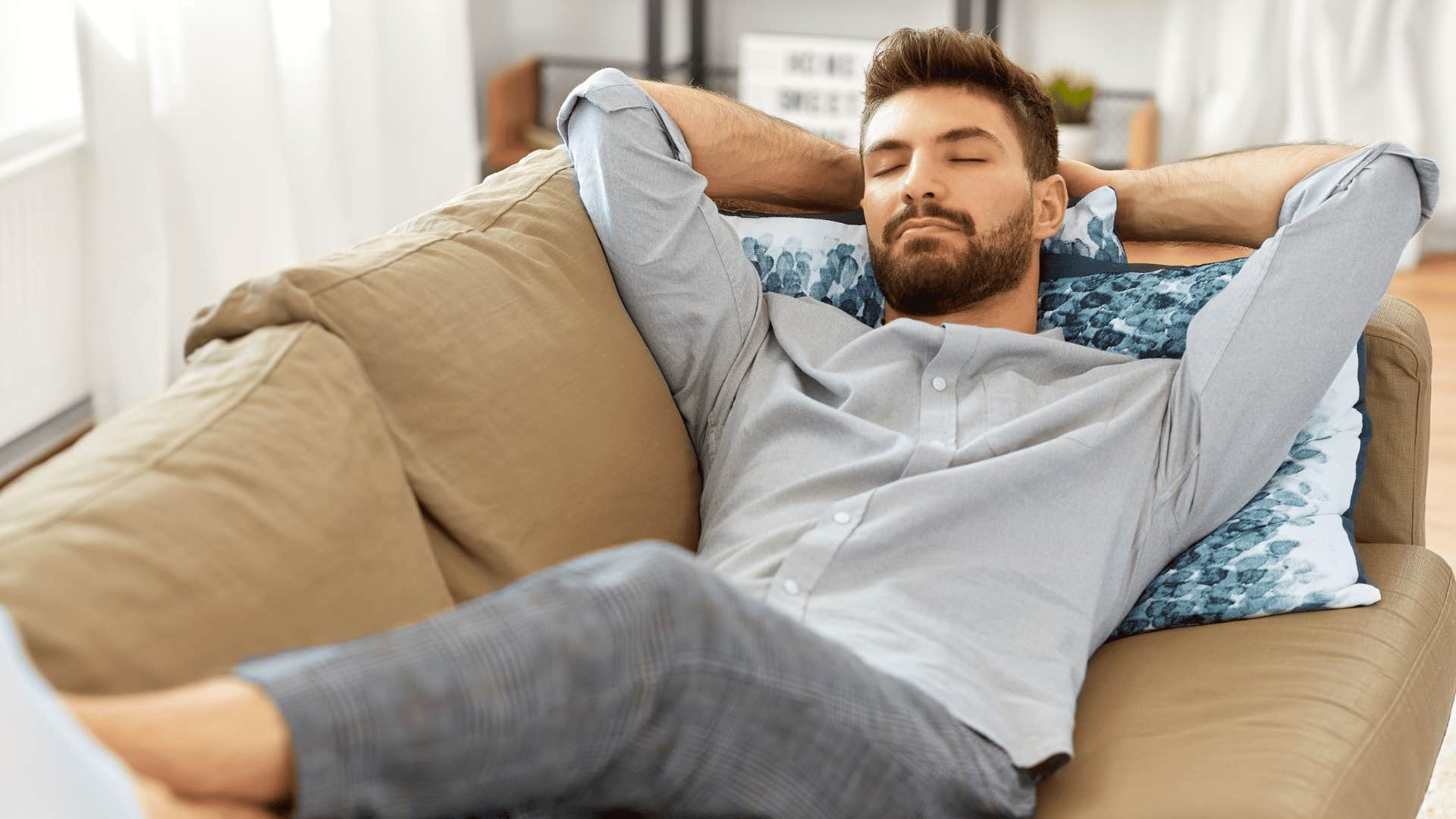 man laying back on couch and relaxing