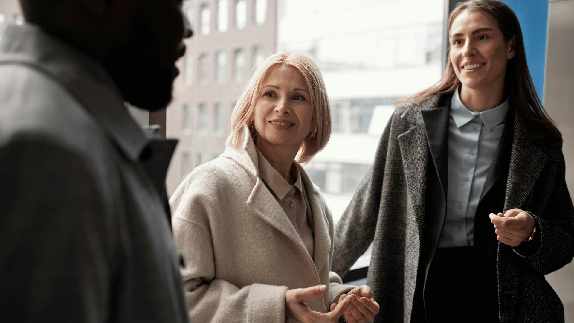 man talking to two smiling women