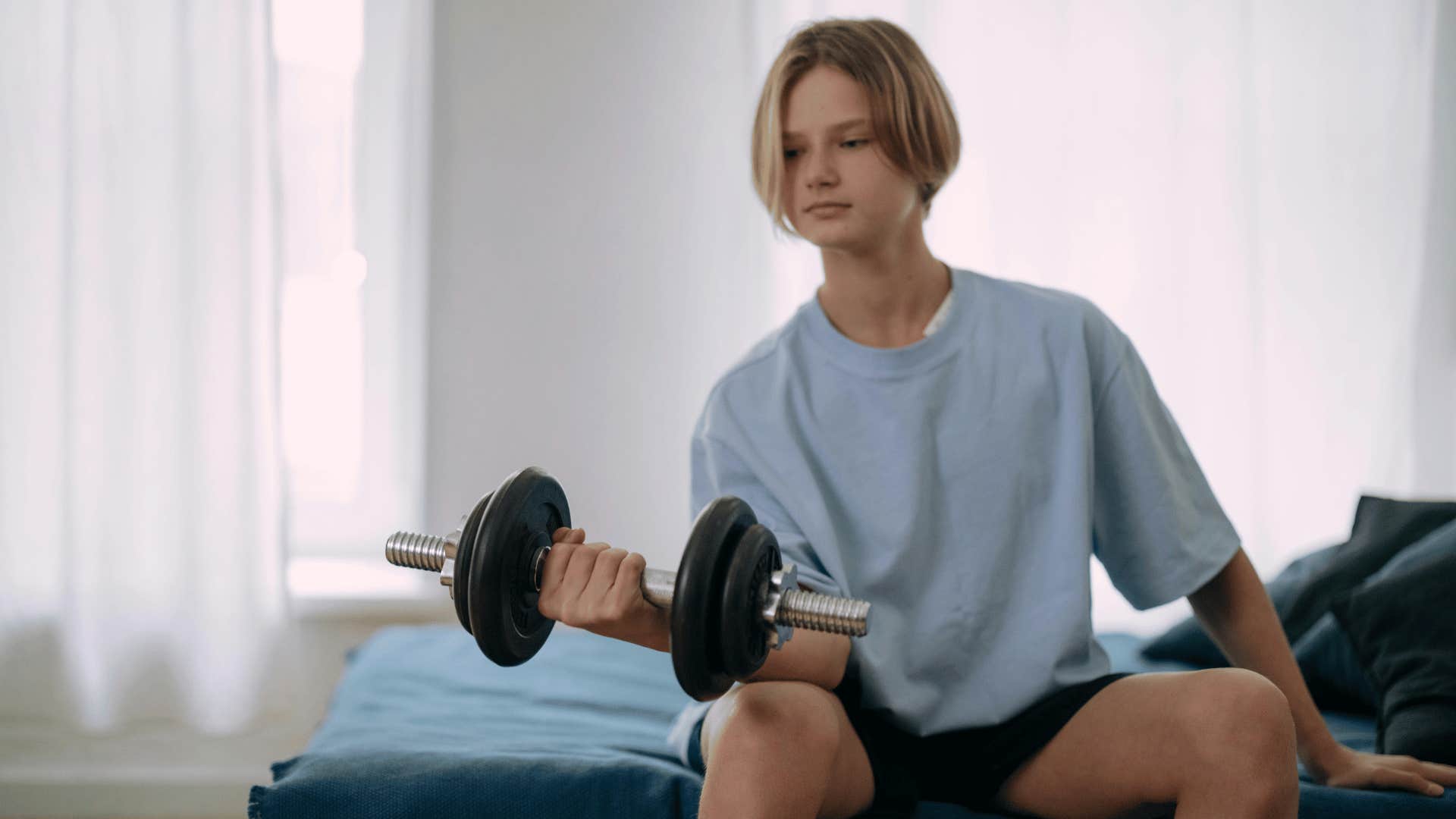 teenage boy lifting weights