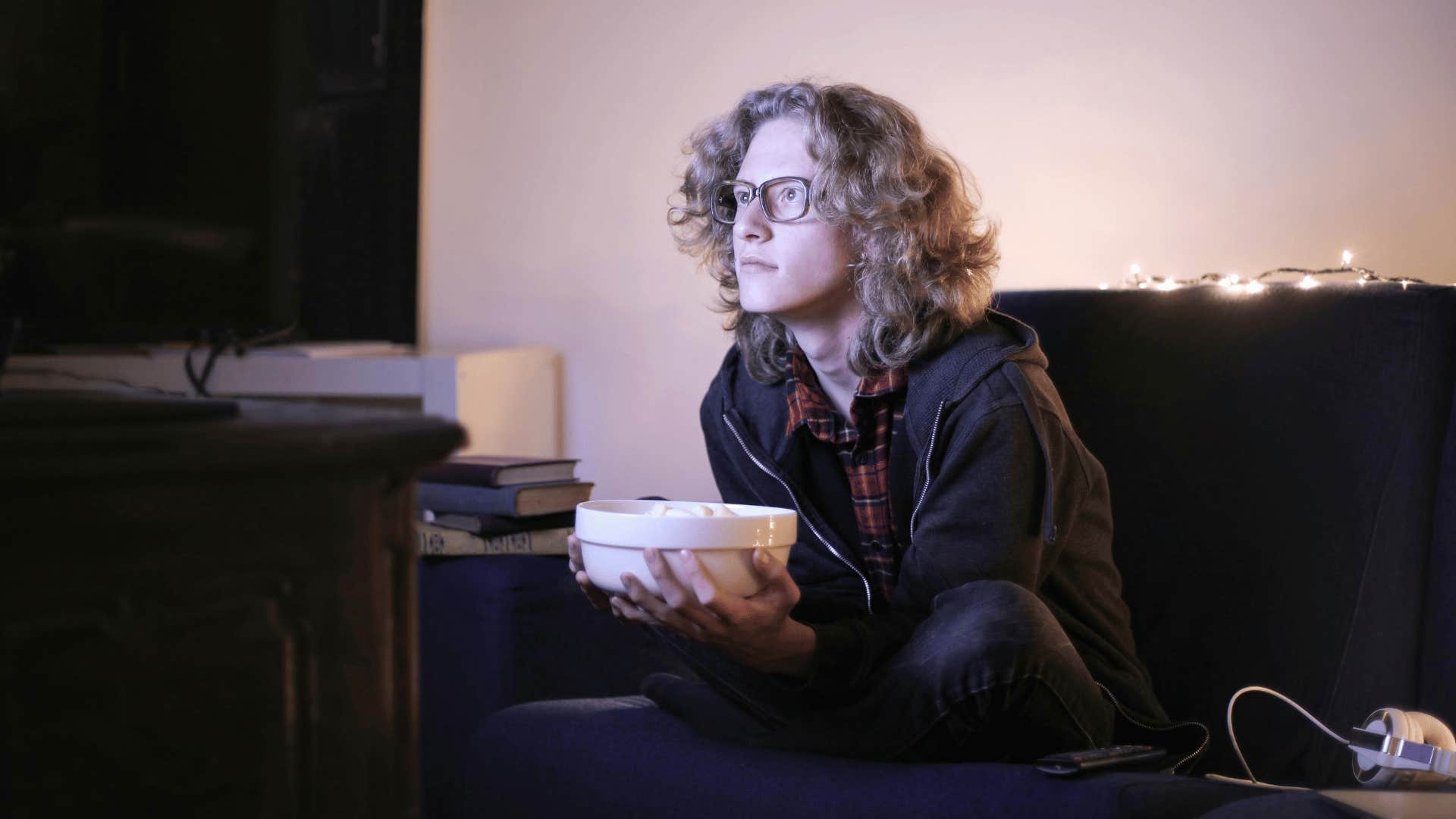 young man sitting close to tv