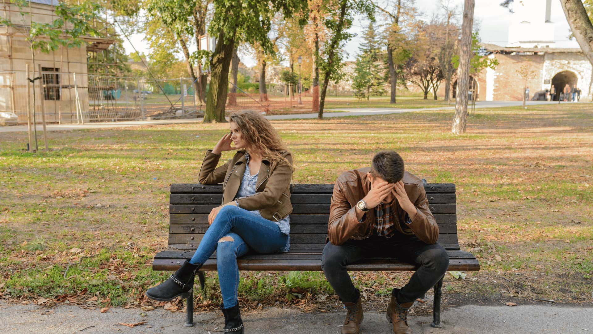 couple turned away from each other on park bench