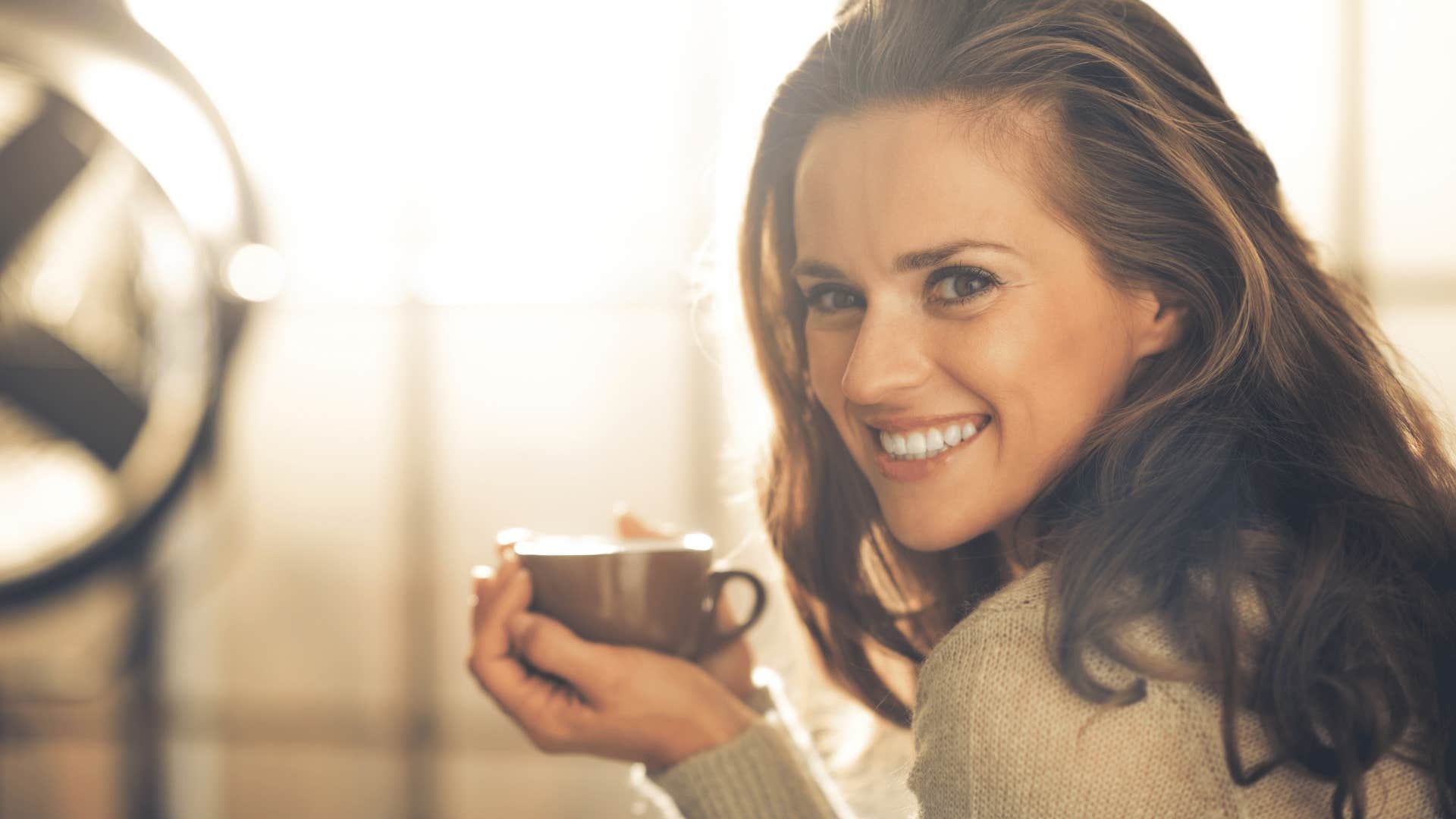 smiling woman holding a mug