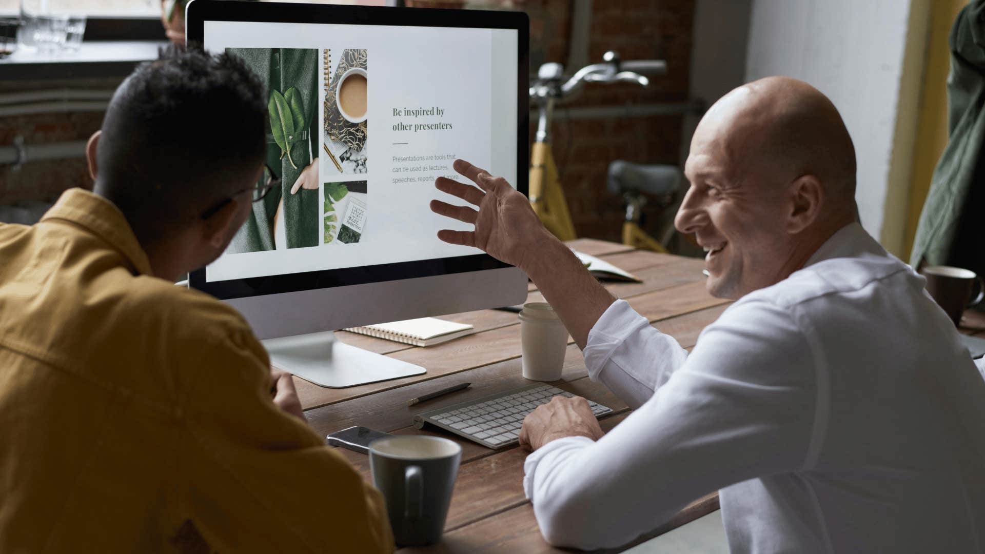 smiling man gesturing at computer