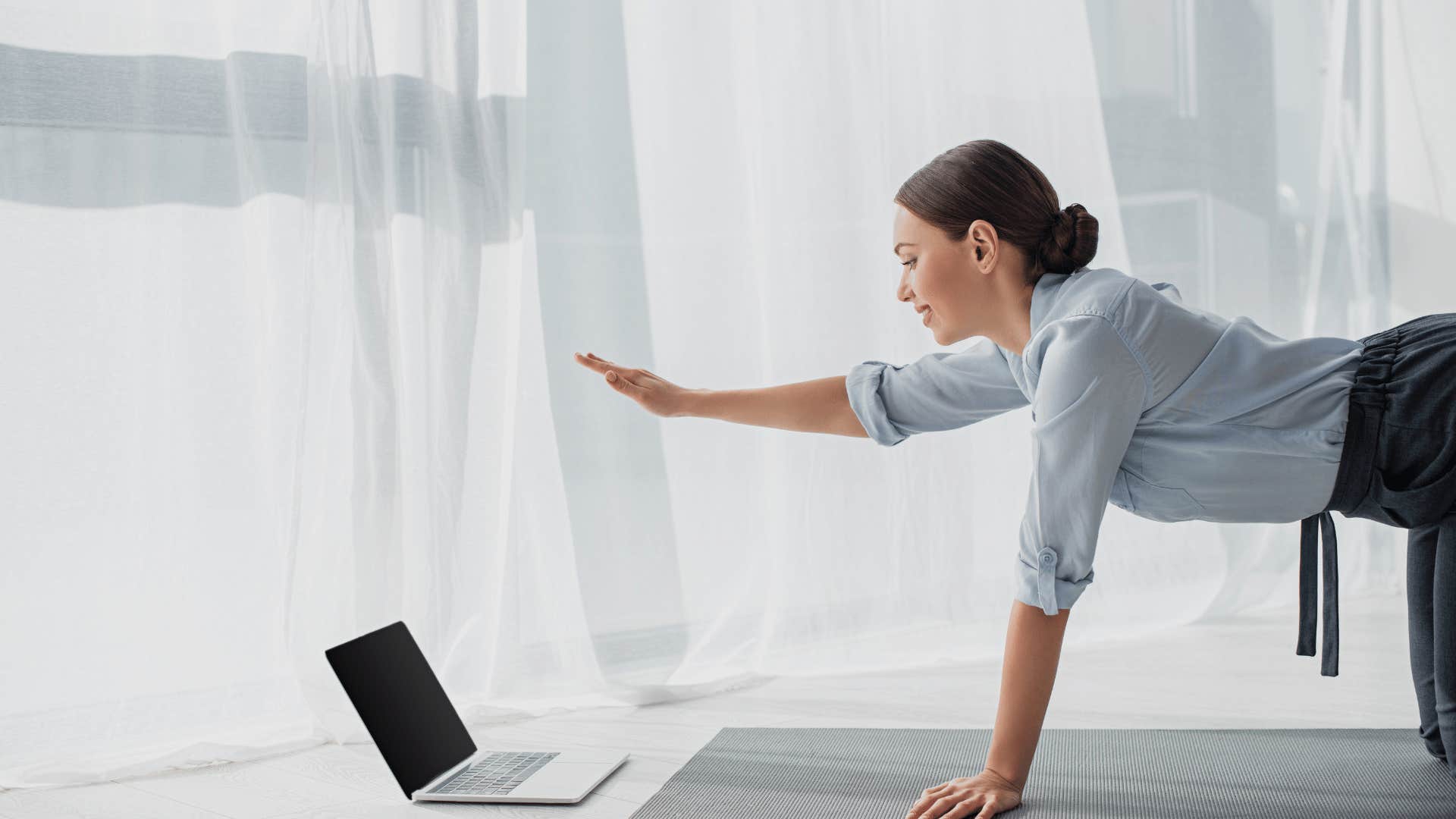 smiling woman in light business clothes with open laptop