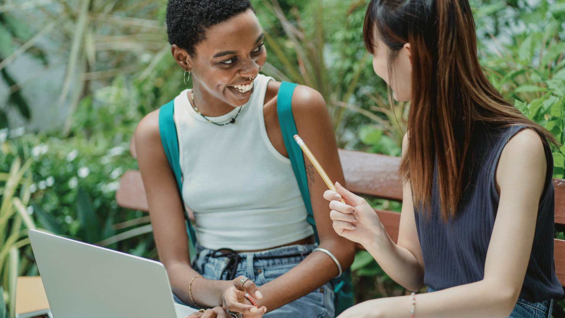 two friends chatting with open laptop