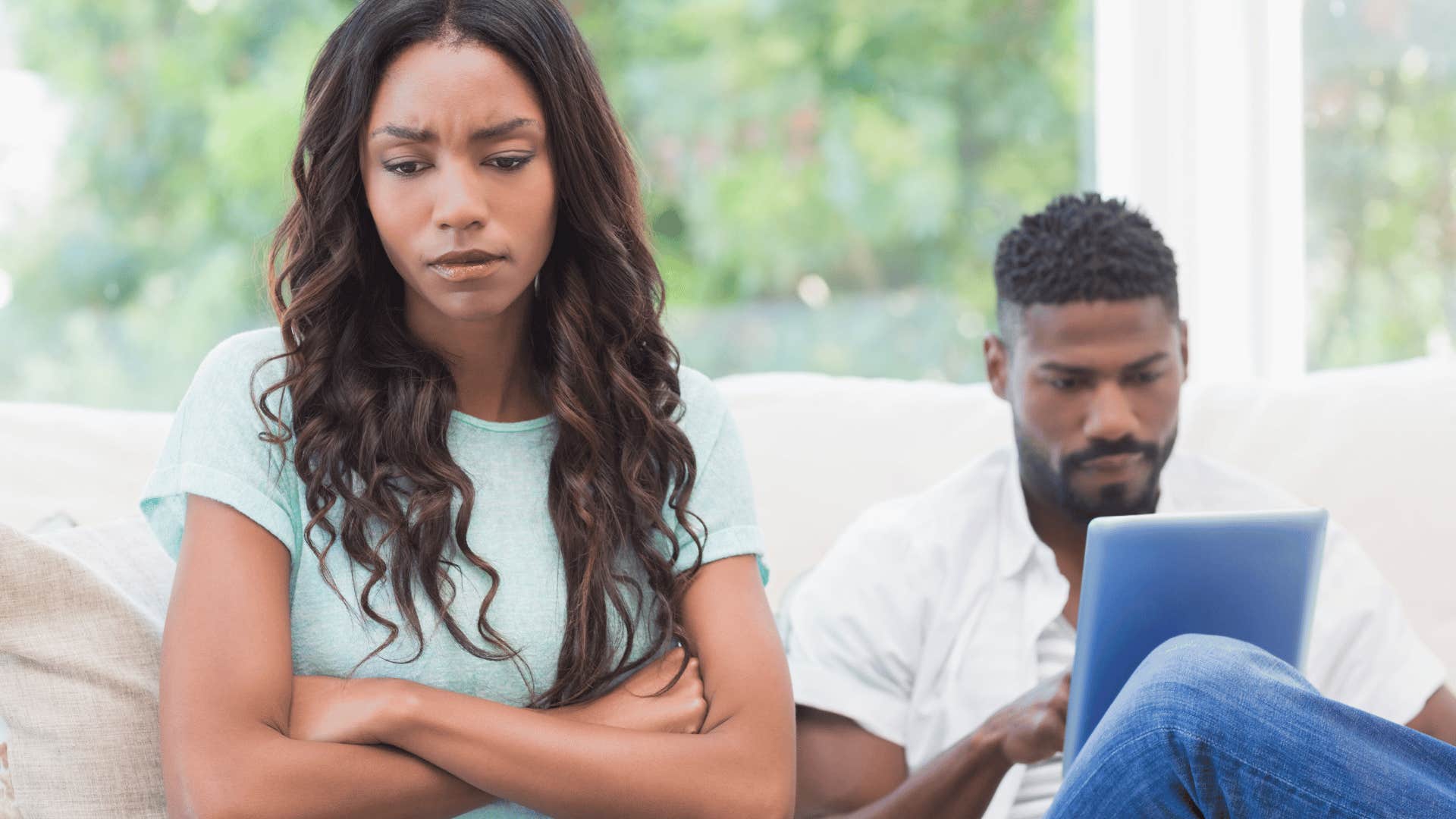 upset woman being ignored by man using tablet