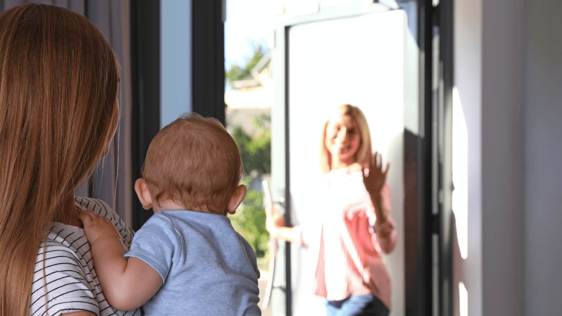 blurry mom waving at babysitter holding baby