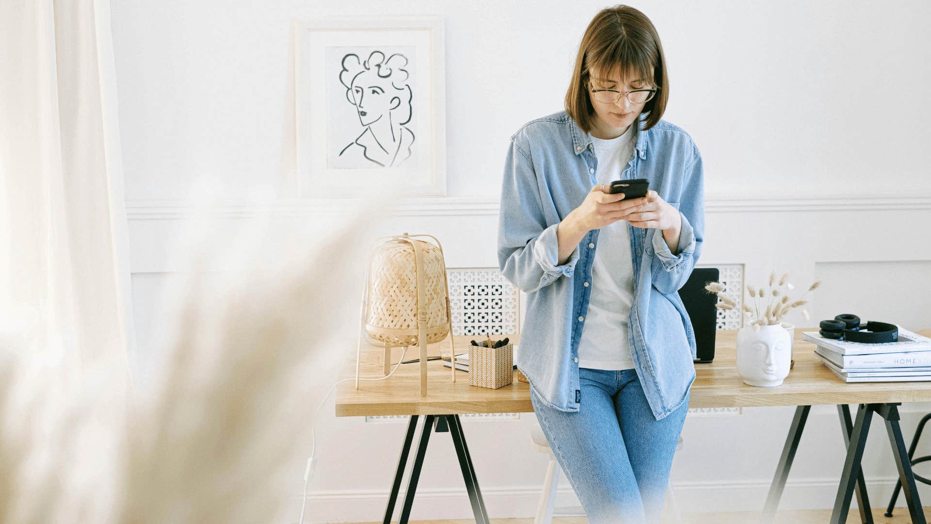 woman leaning against table on phone