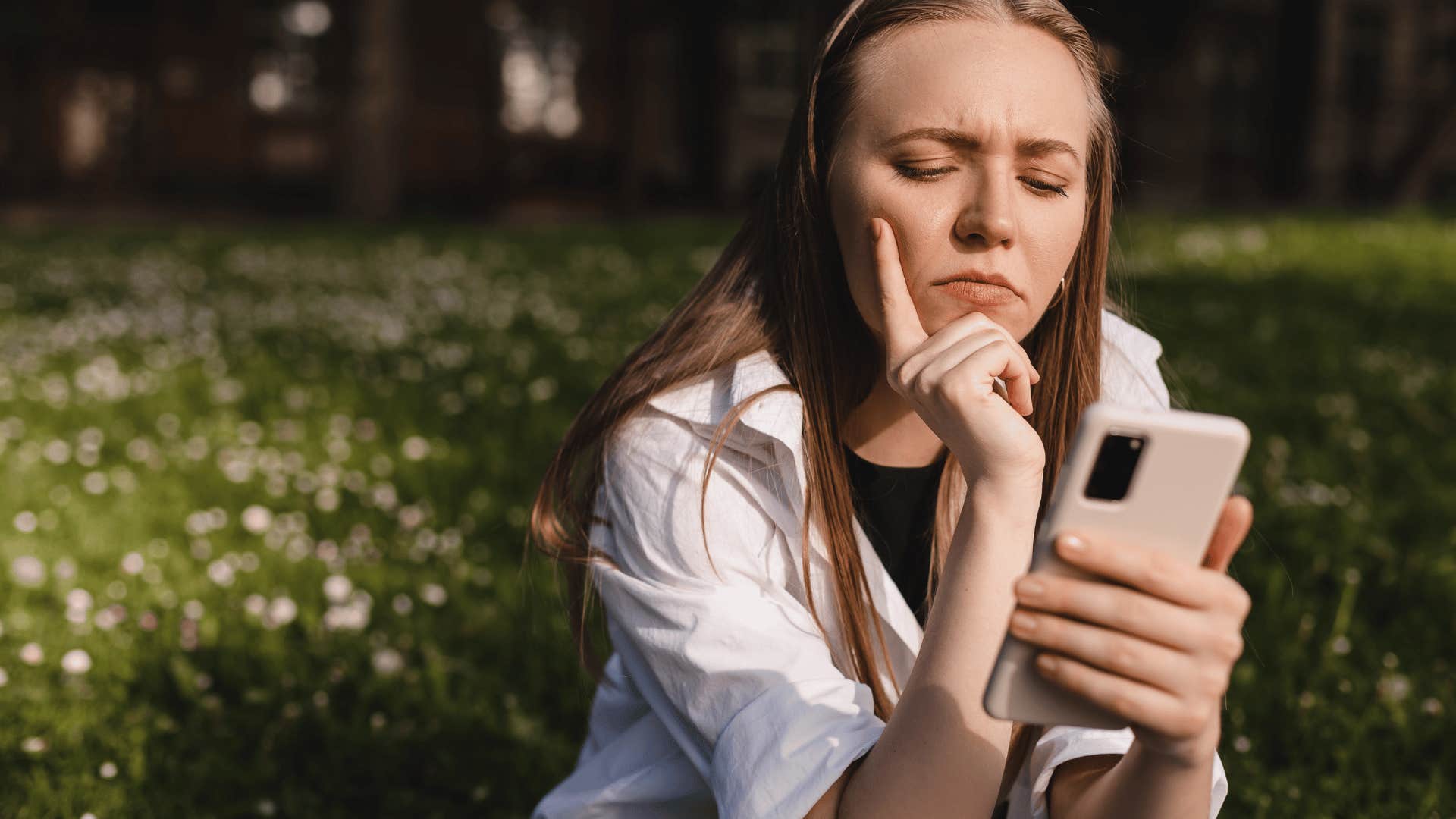 contemplative woman looking at phone