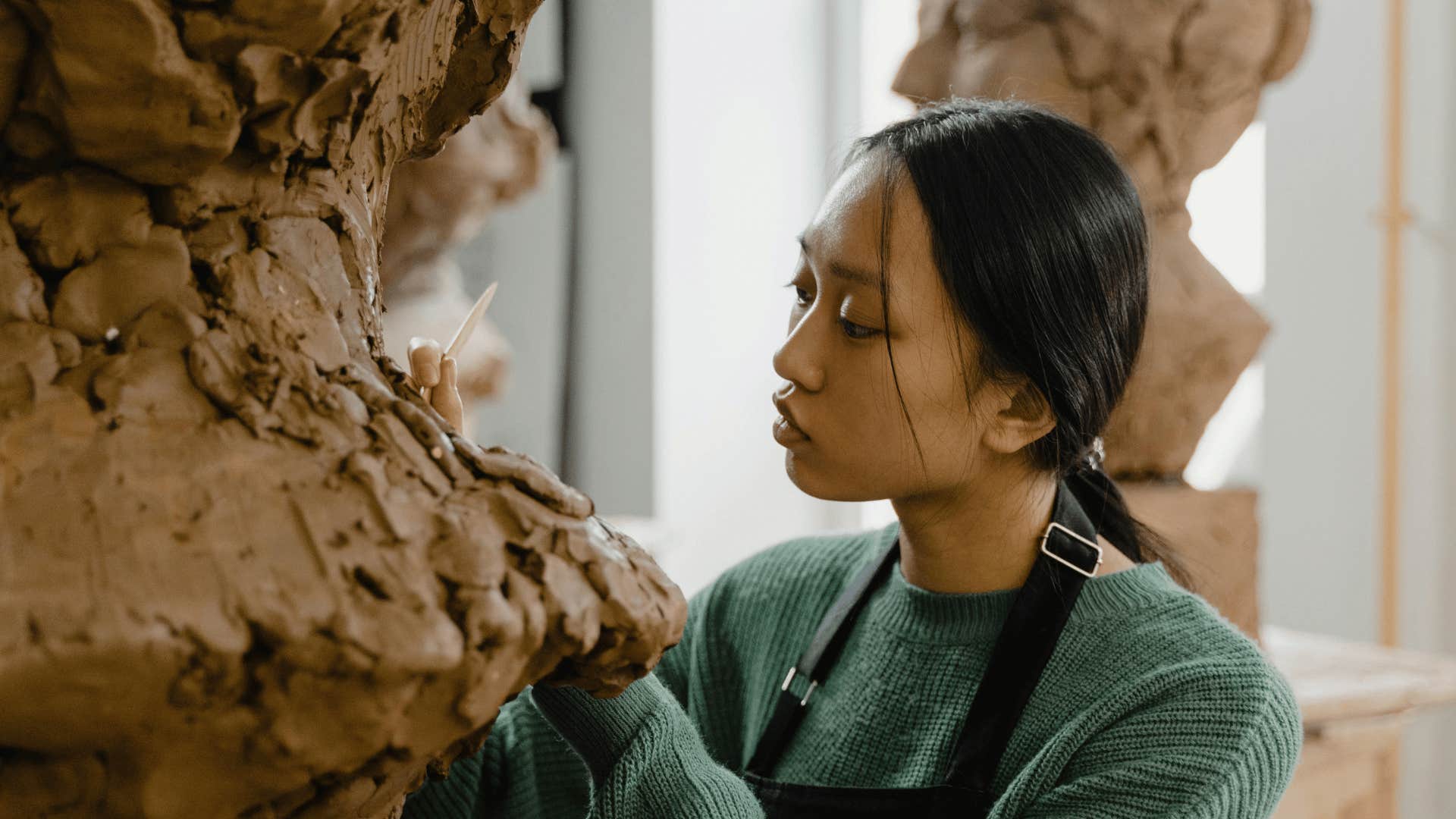 woman working on clay sculpture