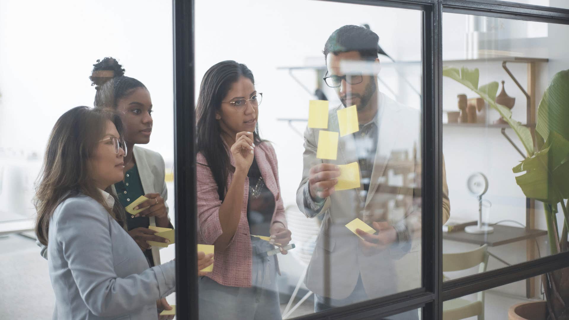 work team brainstorming on glass wall