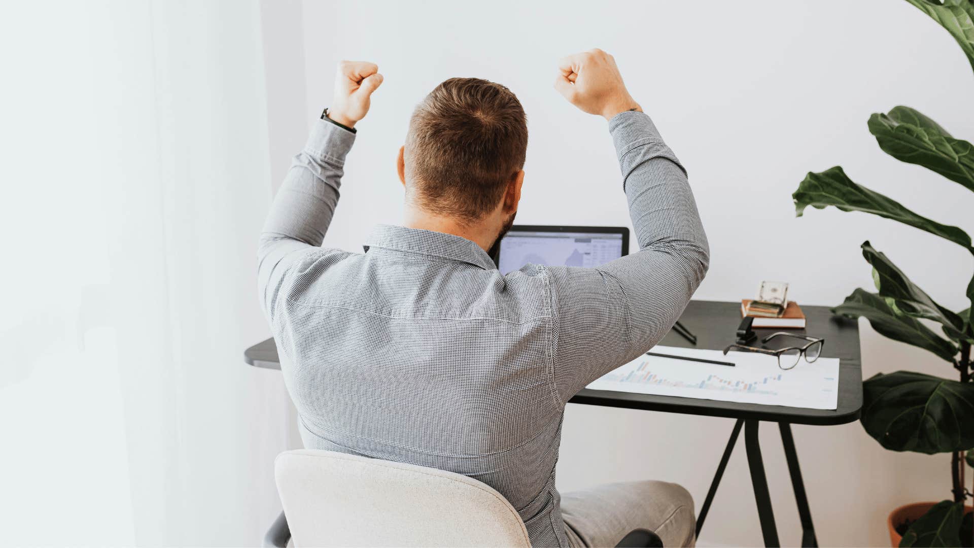 man cheering while working at desk