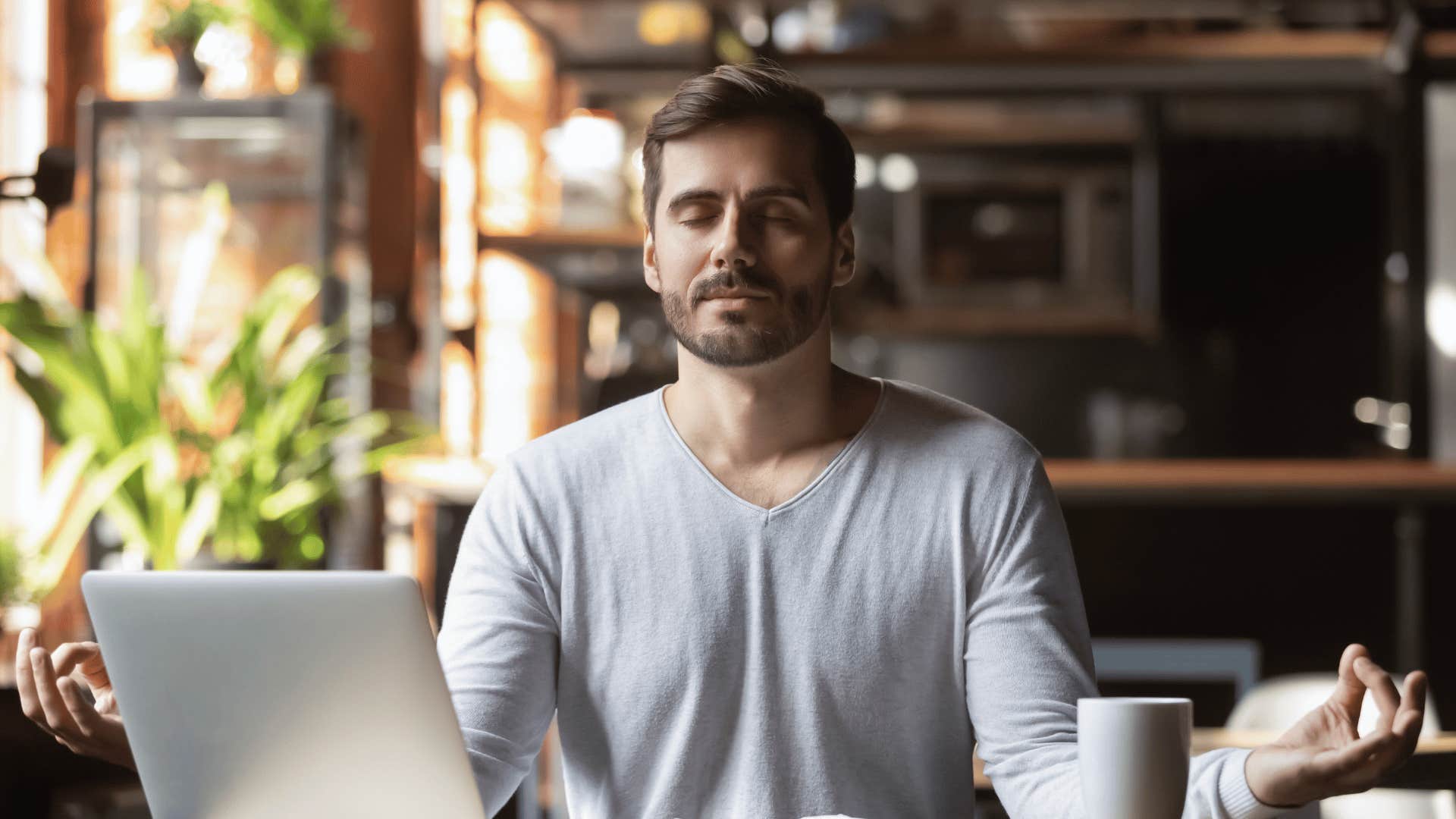 patient man meditating with open laptop