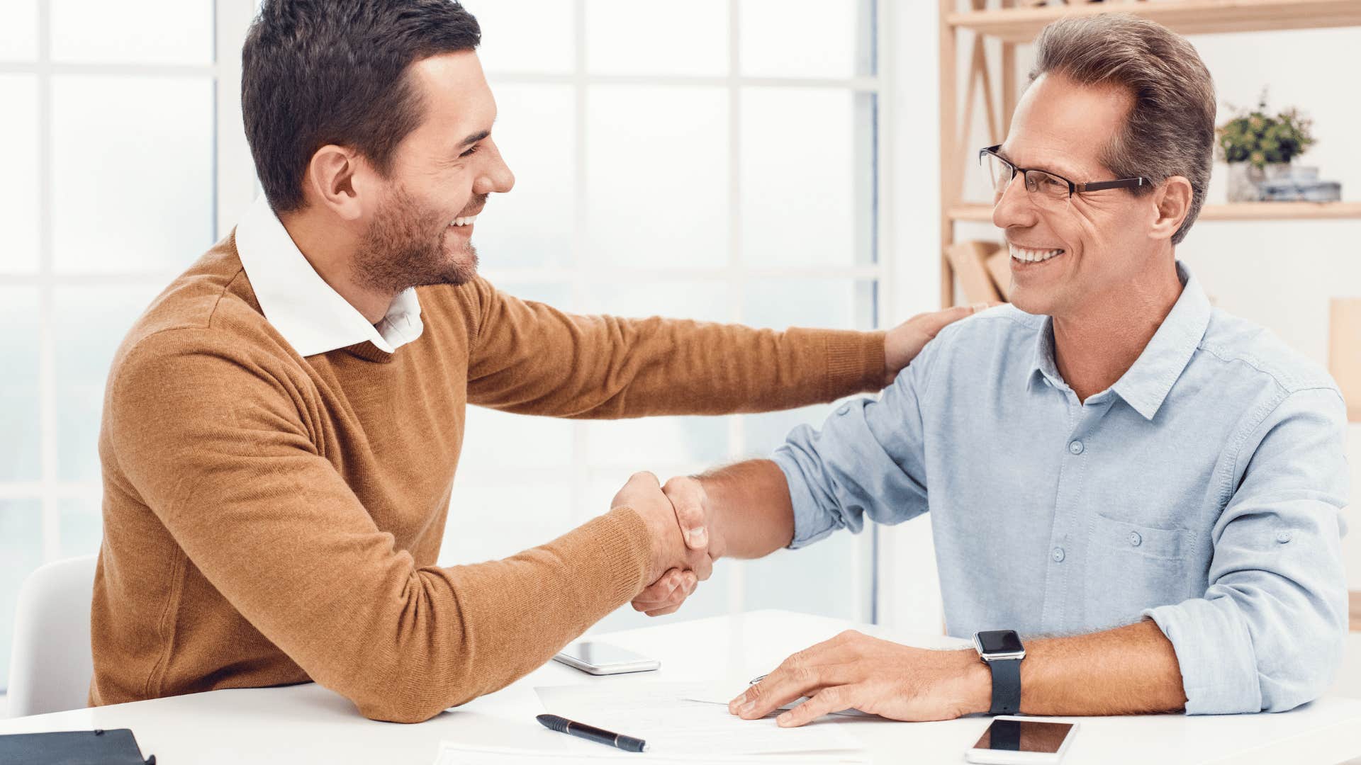 smiling men shaking hands