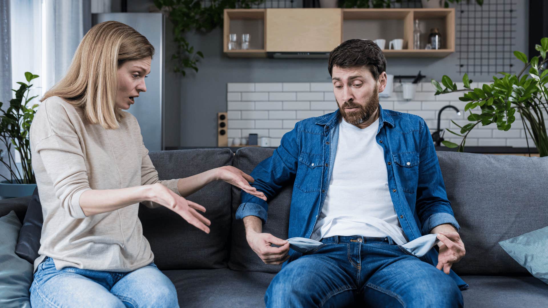 woman shocked at man showing empty pockets