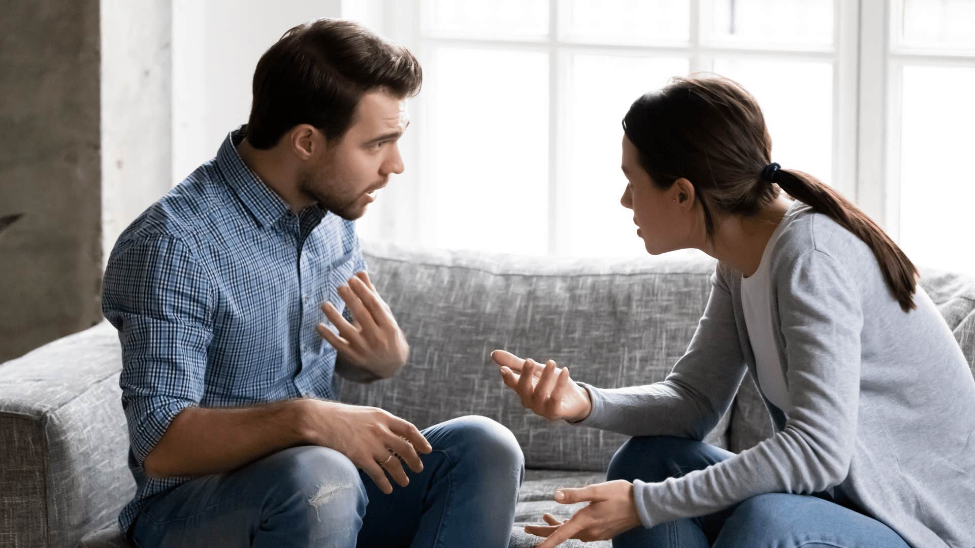 couple arguing with man pointing at his chest