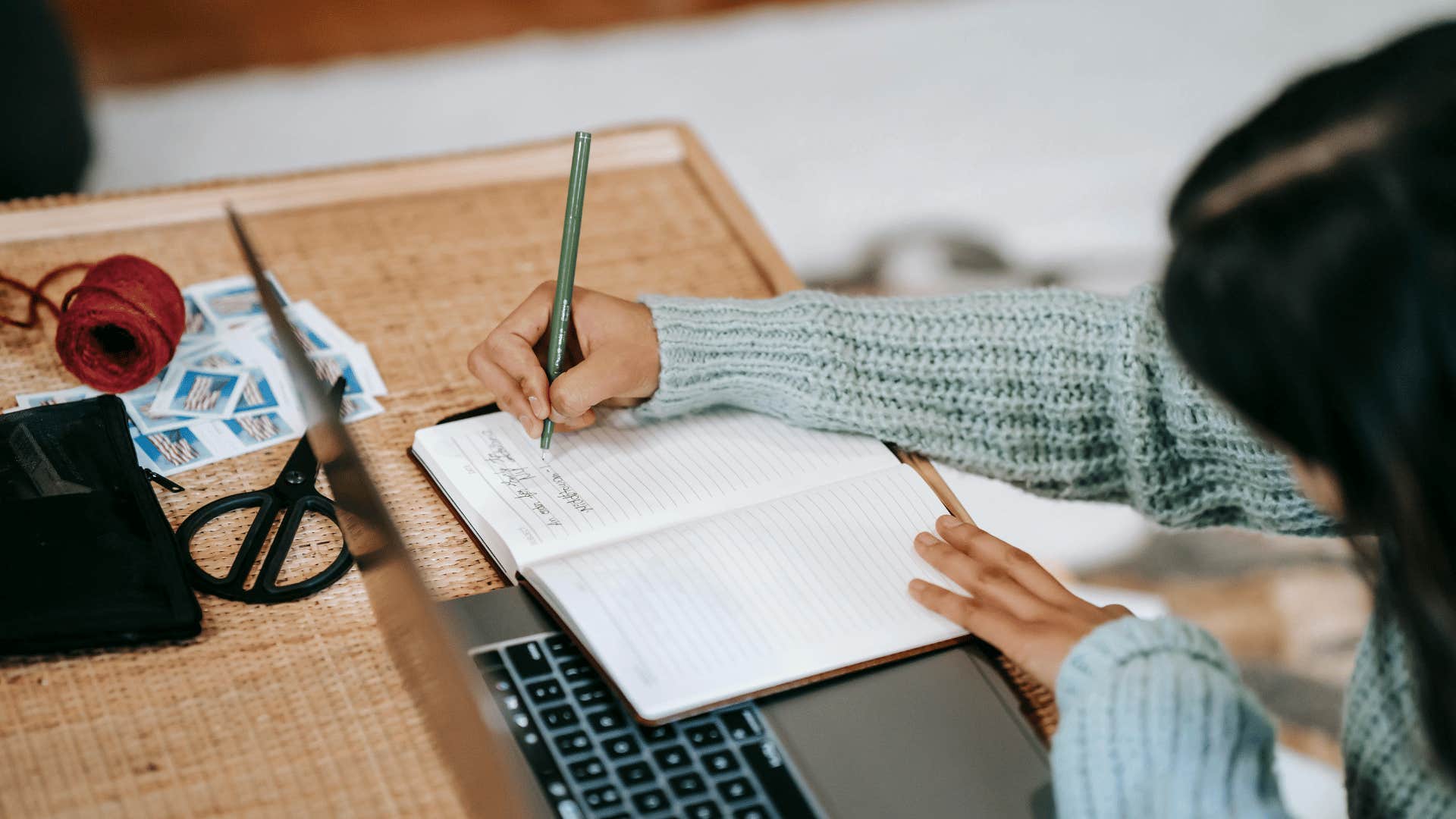 woman writing in open notebook