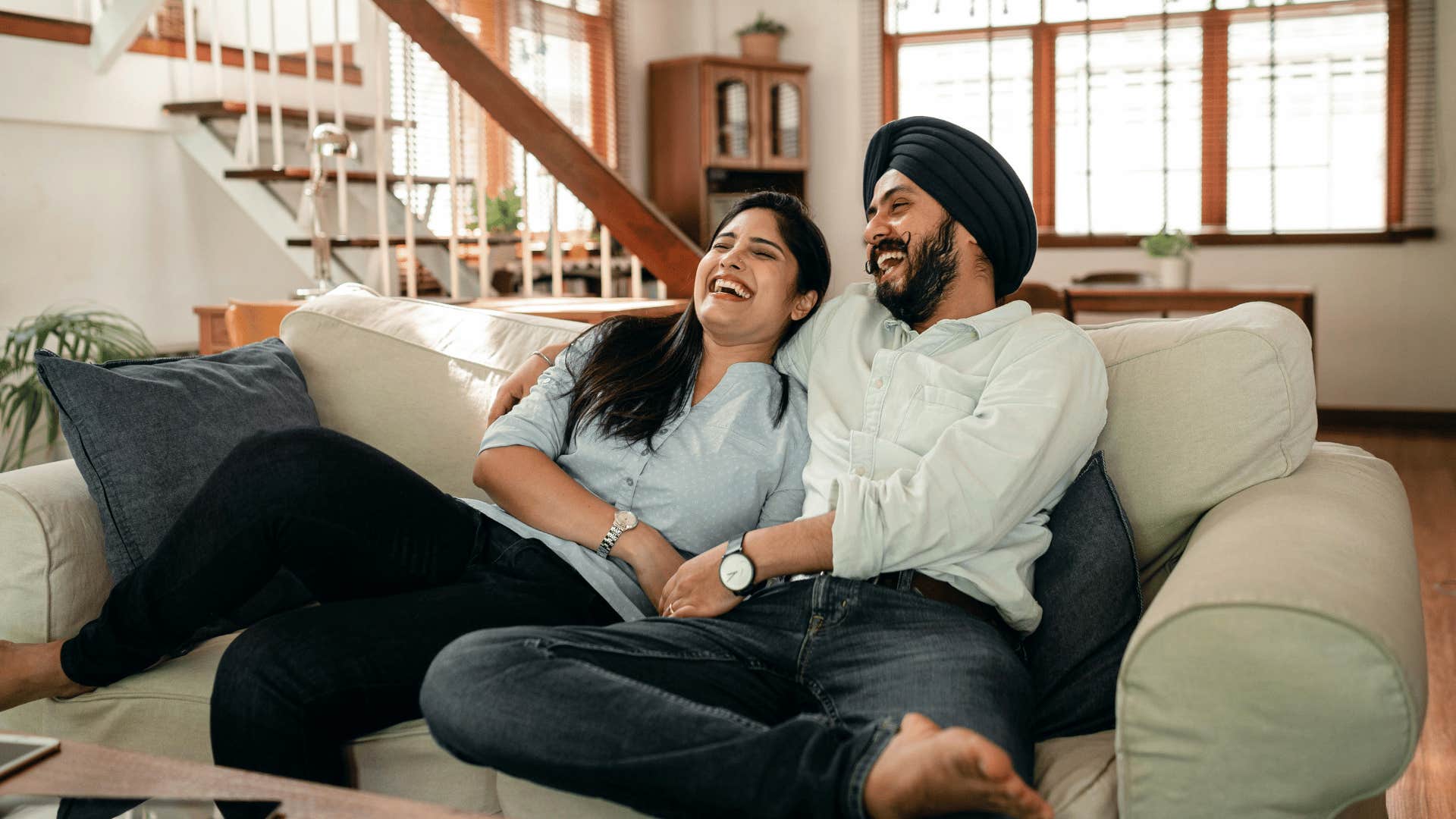 couple laughing together while watching tv