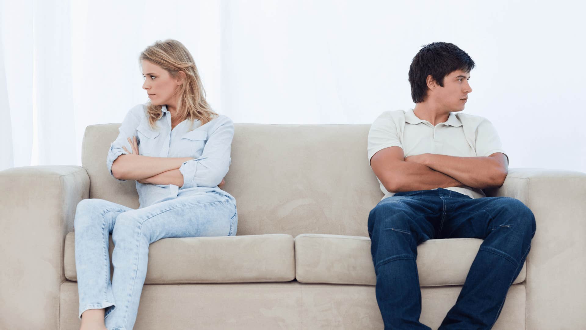 couple on opposite end of a couch looking away