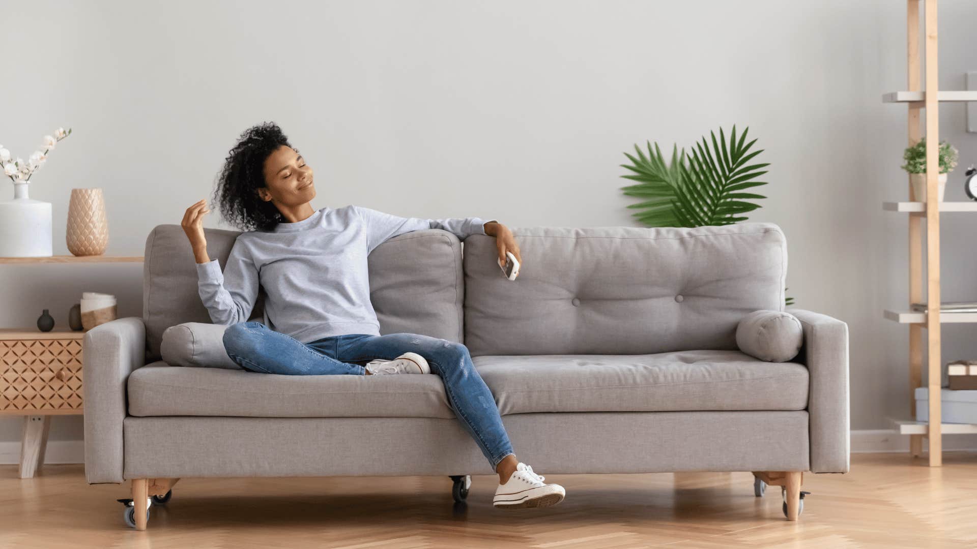 happy woman relaxing on couch alone