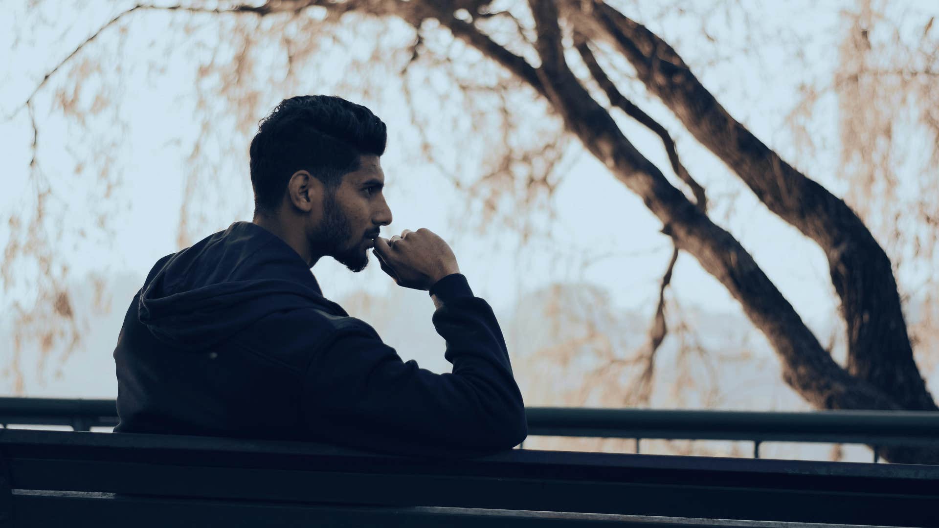 pondering man sitting on bench